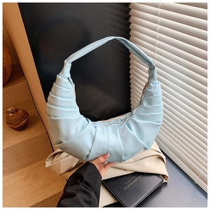 Detail of light blue crescent dumpling bag featuring pleated PU leather and metal zipper