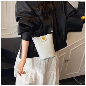 Detailed side view of a light blue pebble leather bucket bag with gold clasp and brand logo