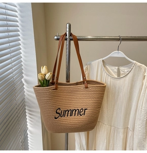 Gros plan d'un sac de plage tressé avec broderie Summer noire et poignées en cuir