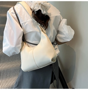 Detail view of cream white leather hobo bag with stitched seams and adjustable strap