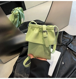 Détail du sac de téléphone vert avocat avec texture litchi, cordon et boucle en argent