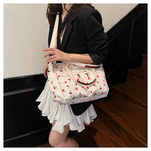 Vue détaillée du sac cabas en toile avec motifs cerises rouges et bandoulière réglable