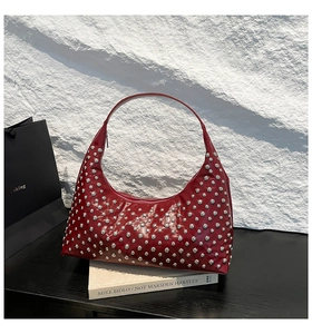 Detail view of red moon bag with silver studs and polished faux leather texture