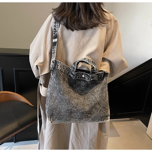 Close-up of vintage grey denim tote bag with silver buckles and adjustable strap