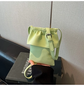 Détail du sac bandoulière vert menthe avec texture litchi et rabat à volants