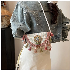 Detailed close-up of Bohemian knit crossbody bag with pink and green tassels for women