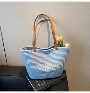 Détail de la broderie Summer sur un cabas tissé bleu clair avec anses en cuir marron