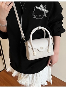 Petit sac carré blanc bandoulière avec texture tressée porté par un mannequin chic