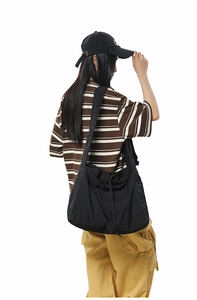 Détail du sac à cordon en nylon noir avec large bandoulière et intérieur spacieux et pratique