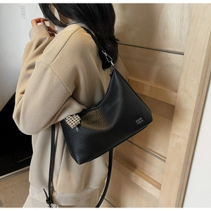 Detail of black lychee grain leather hobo bag with silver buckle and heart charm