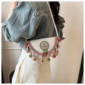 Detail of bohemian shoulder bag featuring colorful tassels and ethnic beaded mandala motif