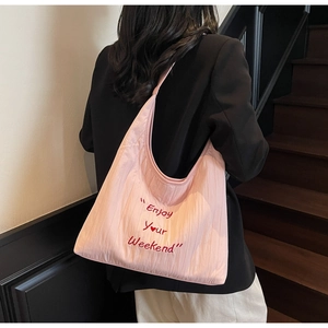 Pink oversized canvas hobo bag with red Enjoy Your Weekend embroidery on textured fabric