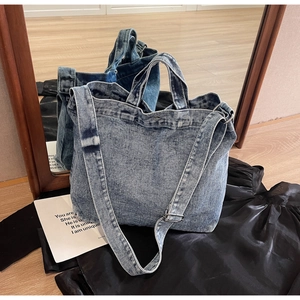 Detailed macro view of washed denim tote bag showing fabric texture and silver rivets
