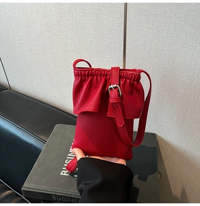 Détail du mini sac rouge en cuir grainé avec bord à volants et bandoulière fine