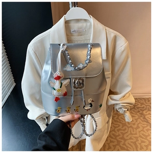 Detail eines silbernen Metallic-Minirucksacks mit Entenstickerei und Rosenmetallverschluss