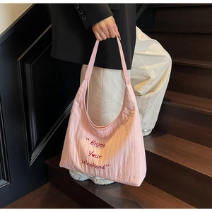 Detail view of pink canvas tote bag with Enjoy Your Weekend print and textured fabric