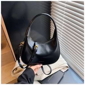 Dettaglio borsa hobo a mezzaluna nera con hardware dorato e trama in pelle pregiata