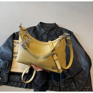Detail of yellow lychee leather crescent shoulder bag with silver metallic charm