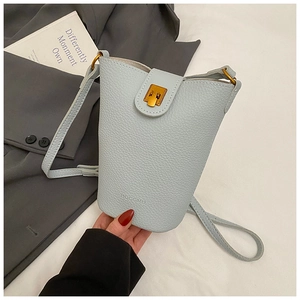 Close-up of light blue leather bucket bag featuring gold metal clasp and brand embossing