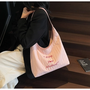 Detail of light pink pleated hobo bag with Enjoy Your Weekend red embroidery