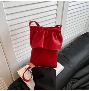 Détail d'un sac seau rouge avec bordure à volants et texture en cuir grainé élégant
