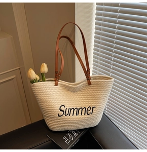 Détail du sac cabas tissé avec broderie Summer et anses en cuir marron élégant