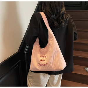Detail of pink quilted tote bag with Enjoy Your Weekend embroidery and heart pattern