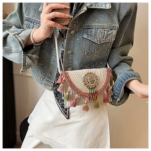 Detail of bohemian woven crossbody bag with colorful tassels and bead embroidered mandala