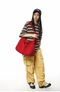 Vue macro du sac à bandoulière rouge avec cordon et texture en nylon plissé imperméable