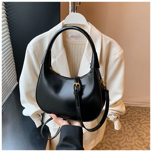 Dettaglio della borsa a mezzaluna nera in pelle premium con accessori in metallo oro
