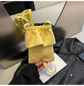 Détail du sac en cuir jaune vif avec volants élégants et fine bandoulière réglable