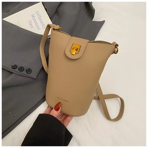 Close-up of light brown lychee textured leather bucket bag with elegant gold metal buckle