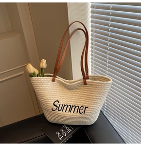 Détail de la broderie Summer et poignées en cuir marron sur cabas tissé blanc cassé