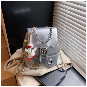 Detail eines silbernen Rucksacks mit Enten-Stickerei und Rosen-Metallverschluss