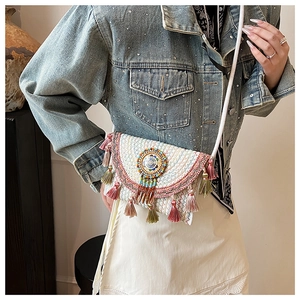 Detailed close-up of Bohemian knit bag featuring ethnic embroidery and colorful tassels