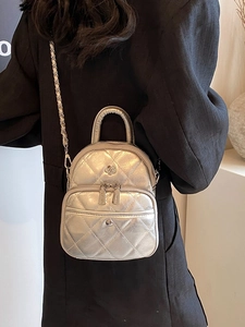 Silver quilted crossbody bag with metal camellia flower on black blazer outfit