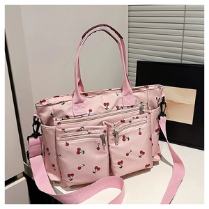 Détail du sac cabas rose à imprimé cerise avec poches zippées et bandoulière réglable