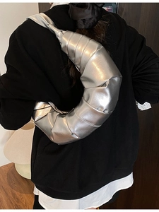 Metallic silver ruched crescent bag on female model with liquid metal finish design