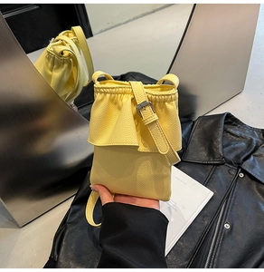 Détail du mini sac bandoulière jaune clair à motif litchi avec fermeture à volants