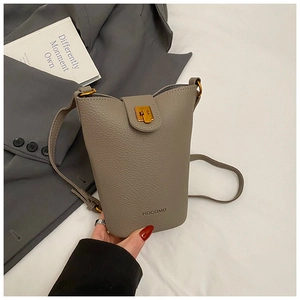 Detail of grey pebble leather bucket bag featuring gold hardware and HOCOMU logo