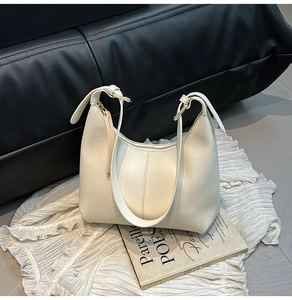 Detailed view of the creamy white hobo bag with adjustable strap and golden metal buckle