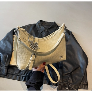 Detail of off-white lychee grain leather tote with heart charm and silver hardware