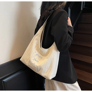 Detail of embroidered 'Enjoy Your Weekend' text on casual off-white canvas hobo tote bag