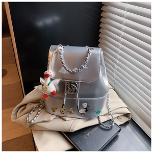 Silberne Metalleffekt-Tasche mit Comic-Stickerei und flauschigem Gänseanhänger im Detail