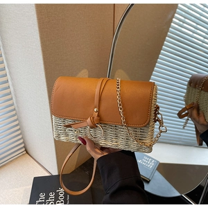 Detail of straw and brown leather crossbody bag with ring detail and gold chain strap
