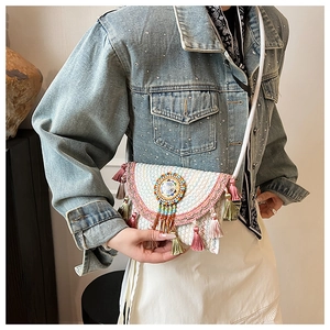 Detail of bohemian knit crossbody bag with vibrant beadwork and colorful tassel accents