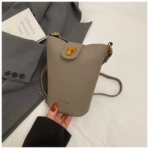 Detail of grey bucket bag with pebble leather texture and elegant gold metal clasp