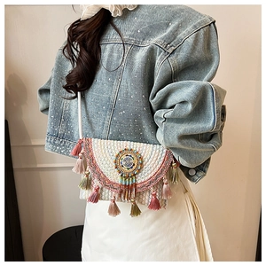 Detail of ethnic knit crossbody bag with colorful wavy embroidery and silk tassels