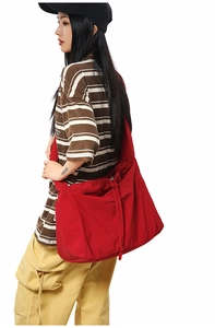 Vue latérale d'un grand sac bandoulière rouge avec cordon et texture plissée