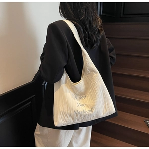 Detail of white pleated canvas tote bag featuring Enjoy Your Weekend blue embroidery